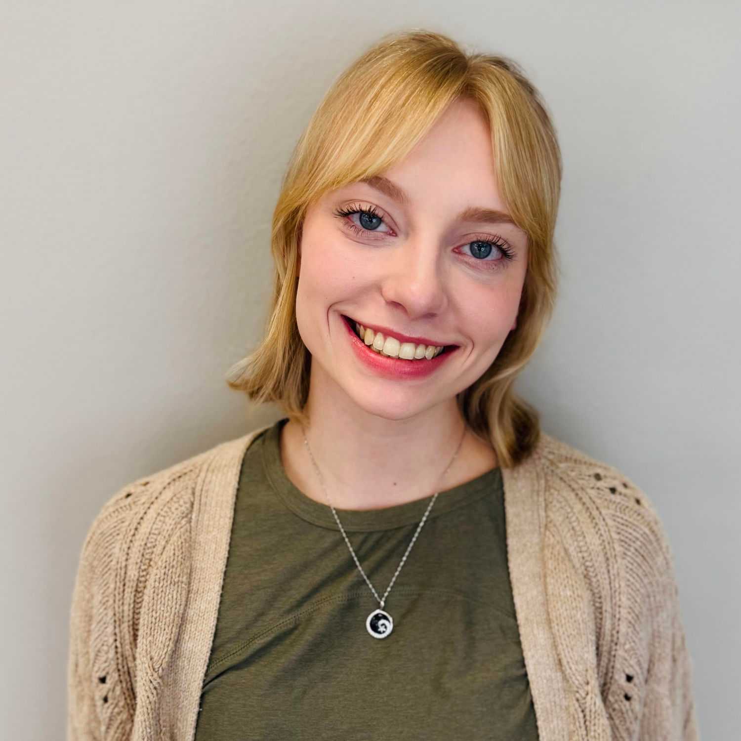 Portrait of Cara Theisen, a professional stylist at Tommy's Salon, showcasing their expertise and style.